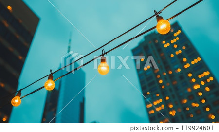 Urban Evening with String Lights and Skyscrapers Illuminated Against Blue Sky 119924601