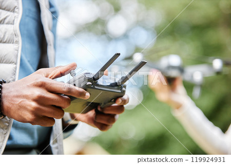 Close up of male hands holding drone controller and pushing buttons while enjoying tech assisted videography outdoors copy space Close up of male hands holding drone controller and pushing buttons while enjoying tech assisted videography outdoors copy space 119924931
