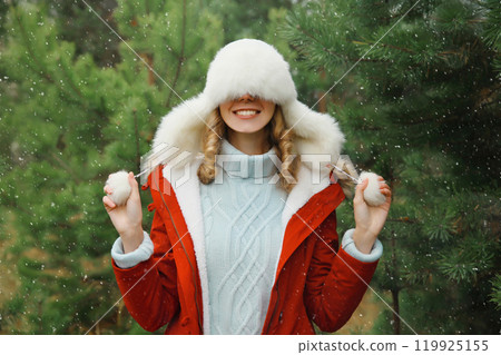 Winter portrait of happy smiling woman having fun enjoys snow against Christmas tree in forest Winter portrait of happy smiling woman having fun enjoys snow against Christmas tree in forest 119925155