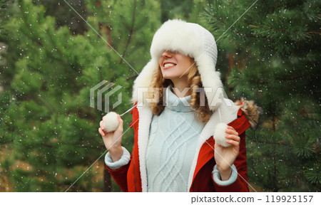 Winter portrait of happy smiling woman having fun enjoys snow against Christmas tree in forest Winter portrait of happy smiling woman having fun enjoys snow against Christmas tree in forest 119925157