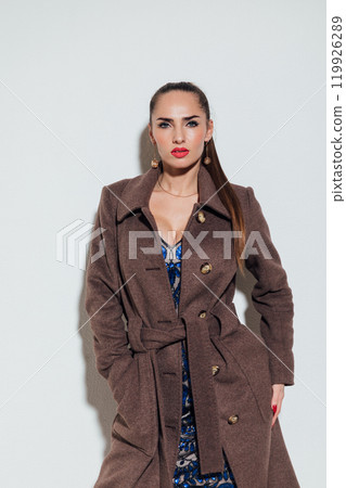 Beautiful fashionable woman in autumn beige coat on gray background Beautiful fashionable woman in autumn beige coat on gray background 119926289