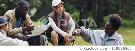 Header image of friends taking break outdoors in nature with smiling Black woman poring hot tea to friend while camping Header image of friends taking break outdoors in nature with smiling Black woman poring hot tea to friend while camping 119926803