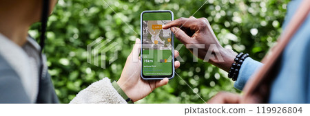 Header image of two tourists using navigation app with map and pointing at smartphone screen while exploring nature trails copy space Header image of two tourists using navigation app with map and pointing at smartphone screen while exploring nature trails copy space 119926804