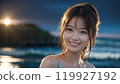 Beautiful Asian woman enjoying the sunset on the beach during her trip 119927192