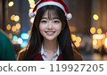 A beautiful Asian woman smiling while wearing a Santa hat among the illuminations 119927205