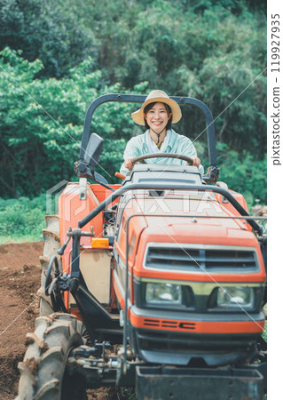 Woman driving a tractor Woman driving a tractor 119927935
