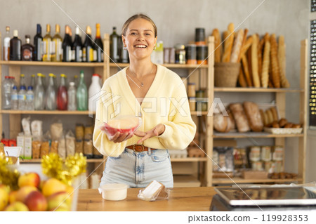 Customer near self-service counter hangs purchases on scale. Girl puts vacuumed products on scales 119928353