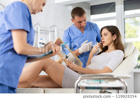 Cosmetologist showing results of facial procedure to young woman 119928354