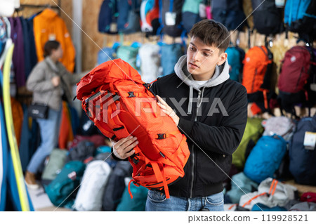Buyer guy chooses winter backpack in store for hikes 119928521