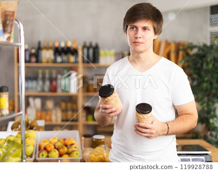 Young man choosing beans in grocery store 119928788