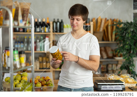 Young man choosing olives at grocery store 119928791