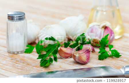 Garlic with parsley and olive oil on table Garlic with parsley and olive oil on table 119928917