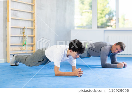 Man and teenage boy train their abs Man and teenage boy train their abs 119929006