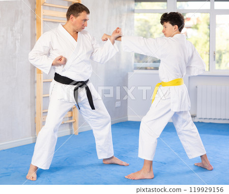 Man and teenage boy training karate fight Man and teenage boy training karate fight 119929156