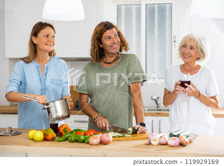 Happy family together with elderly mother preparing lunch in kitchen Happy family together with elderly mother preparing lunch in kitchen 119929169