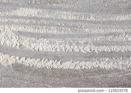 Grey cooking background of spilled wheat flour on stone background, top view. 119929576