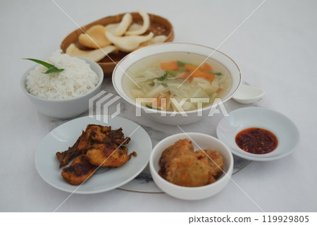 traditional Indonesian meal arranged neatly on a white surface 119929805