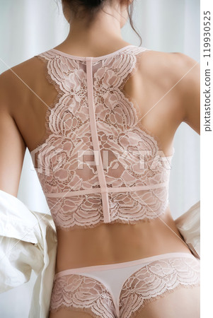 Woman wearing pink lacy underwear and removing white shirt, advertising concept Woman wearing pink lacy underwear and removing white shirt, advertising concept 119930525