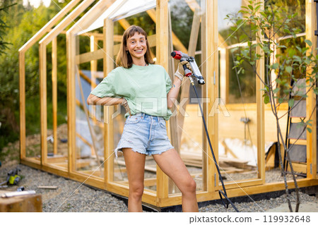 Female Carpenter Using Nail Gun Female Carpenter Using Nail Gun 119932648