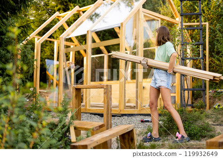 Female Carpenter Carrying Wooden Planks Female Carpenter Carrying Wooden Planks 119932649