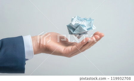 A hand holding a crumpled banknote, symbolizing finance, business ideas, and the value of money in a modern setting. 119932708