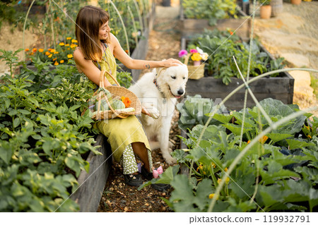 Woman with her dog in eco-friendly garden 119932791