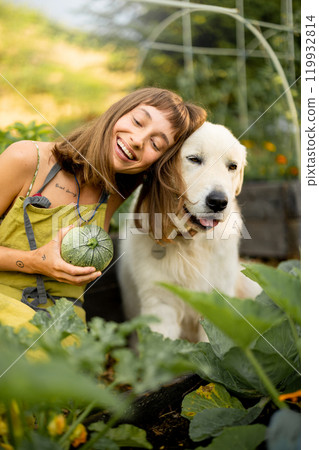Woman with her dog in eco-friendly garden 119932814