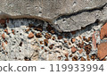 Close-up of textured wall with cracks and stones, ideal for construction or design. 119933994