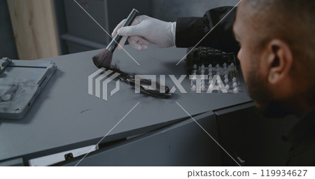 Close up of African American policeman or forensic scientist searching for fingerprints Close up of African American policeman or forensic scientist searching for fingerprints 119934627