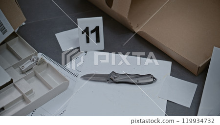 Close up of knife lying next to numbered marker at crime scene Close up of knife lying next to numbered marker at crime scene 119934732