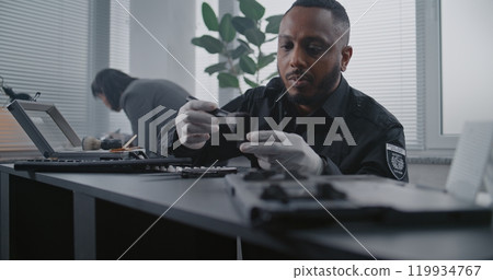 Murder case: Close up of African American police officer finding fingerprints on knife 119934767