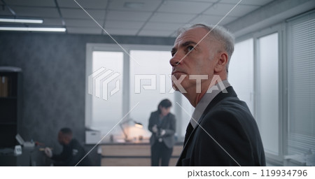 Office robbery case: Medium close up of male detective examining crime scene Office robbery case: Medium close up of male detective examining crime scene 119934796