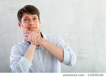Young guy holding his cheek with toothache 119936180