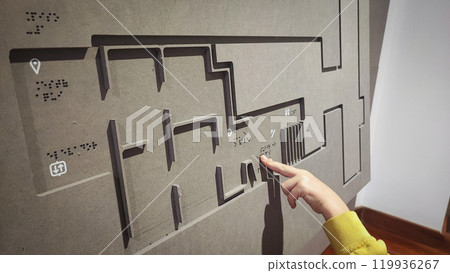 A boy reading the evacuation plan on the wall in braille. Close-up of a child reading braille. The concept of inclusiveness. World Sight Day. World Braille Day A boy reading the evacuation plan on the wall in braille. Close-up of a child reading braille. The concept of inclusiveness. World Sight Day. World Braille Day 119936267