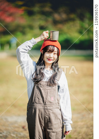 一個年輕女子,臉上帶著幸福的表情,頭上戴著杯子 一個年輕女子,臉上帶著幸福的表情,頭上戴著杯子 119936570