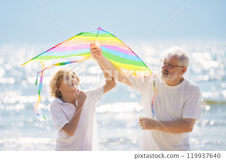 Grandfather and kids play on summer beach 119937640