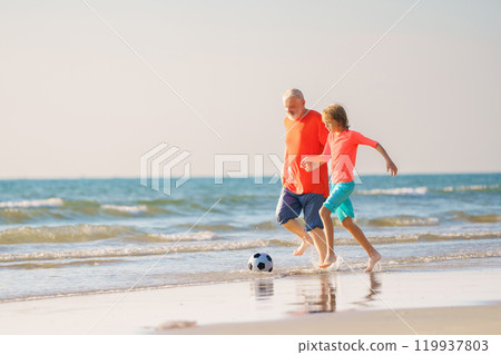 Grandfather and kids play football on beach. 119937803