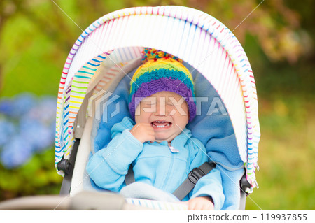 Baby boy in stroller in autumn park 119937855
