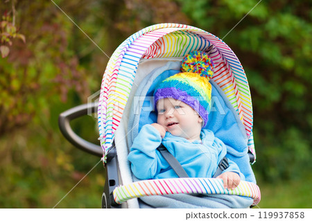 Baby boy in stroller in autumn park Baby boy in stroller in autumn park 119937858