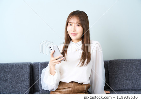 便衣的年輕女人，客廳，智能手機 119938530