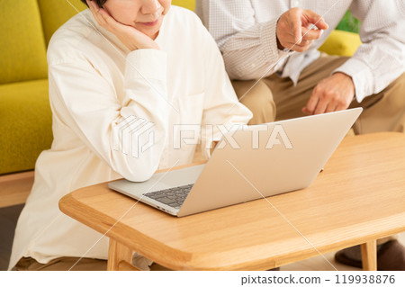 中老年夫婦在客廳看電腦 119938876