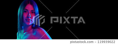 Banner. Young woman with long, healthy air looking at cameras in bright neon light against black background. with negative space to insert text 119939022