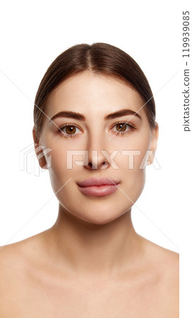Close-up photo of pretty young brunette woman against white background. Facial asymmetry and lifting Close-up photo of pretty young brunette woman against white background. Facial asymmetry and lifting 119939085