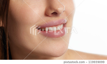 Cropped photo of young woman with perfect smile and plump lips against white background. Lips augmentation. Cropped photo of young woman with perfect smile and plump lips against white background. Lips augmentation. 119939099