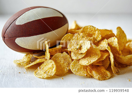 Chips with a rugby ball on gray background. Super bowl concept 119939548