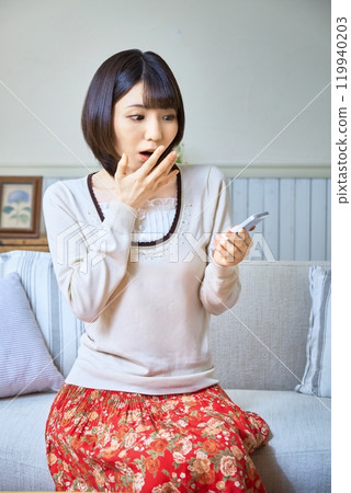A woman surprised to see a smartphone 119940203