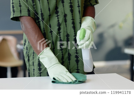 Front view close up of male hands cleaning table with sanitizing spray and wearing rubber gloves, copy space Front view close up of male hands cleaning table with sanitizing spray and wearing rubber gloves, copy space 119941178