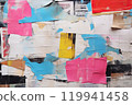 Urban Tapestry A Visual Symphony of Old Wrinkled Grunge Ripped Torn Placard Posters Background, Featuring Weathered Advertising Poster Pieces in White, Pink, Blue, and Yellow Colors on a Wall.. 119941458