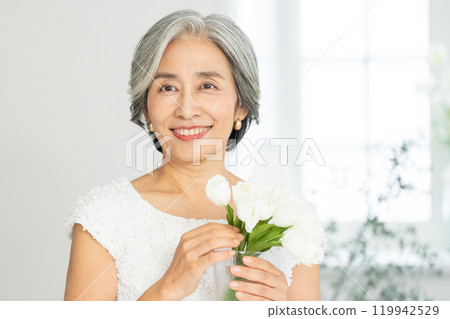 Smiling senior woman holding flowers 119942529