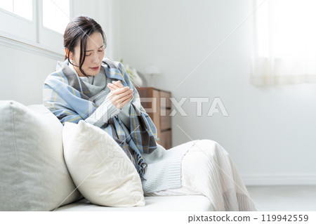 一位對寒冷敏感且感覺不舒服的年輕女性。 119942559